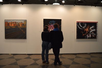 two people look at artwork in a college of fine arts gallery