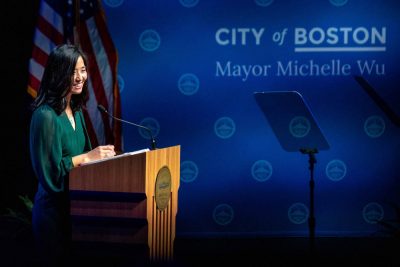 吴市长站在讲台后微笑。她身后的投影是“波士顿市市长吴亦凡”