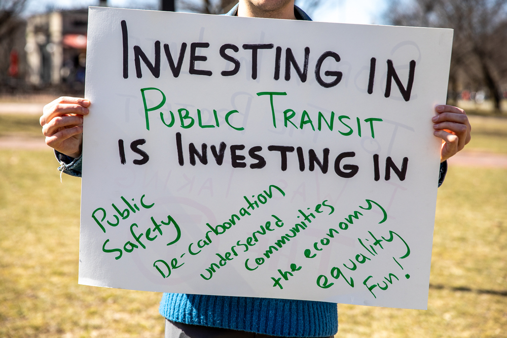 一名抗议者举着促进公共交通投资的标语bobapp下载